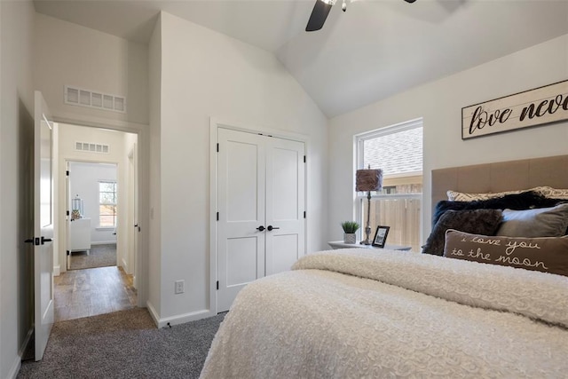 bedroom with high vaulted ceiling, a closet, dark carpet, and ceiling fan