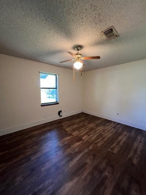 spare room featuring ceiling fan, a textured ceiling, and dark wood-type flooring