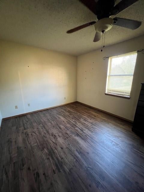 empty room featuring ceiling fan, dark hardwood / wood-style flooring, and a textured ceiling