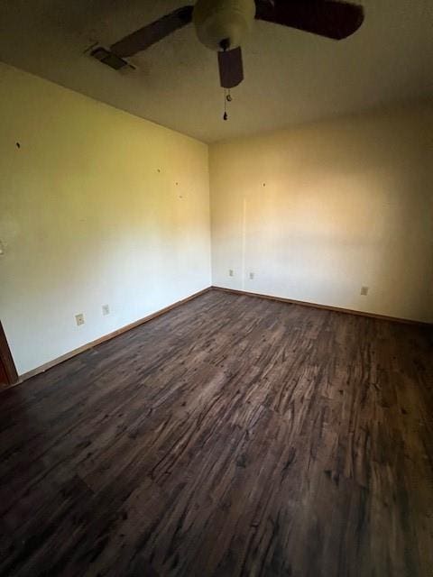 empty room with ceiling fan and dark wood-type flooring