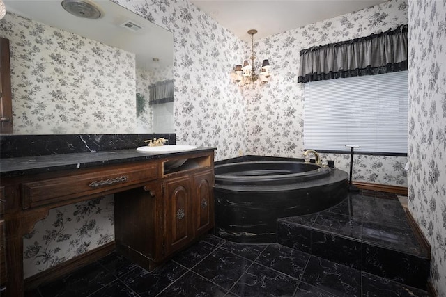 bathroom featuring vanity, a chandelier, and a tub to relax in