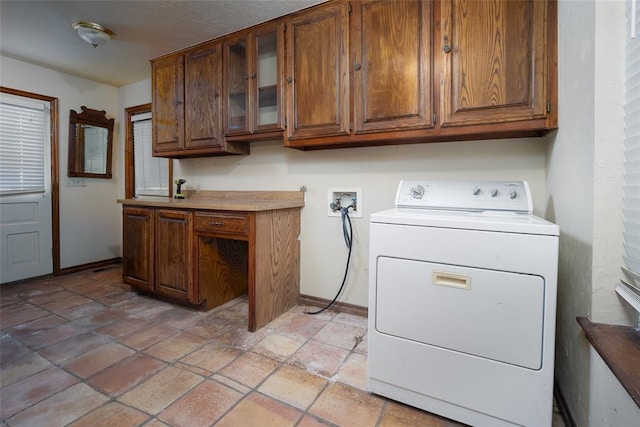 clothes washing area featuring washer / clothes dryer and cabinets