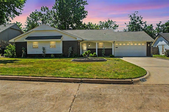 ranch-style home with a garage and a yard