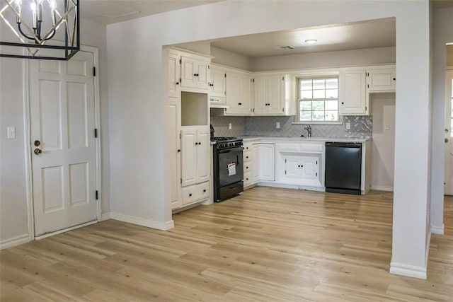 kitchen featuring white cabinetry, an inviting chandelier, black appliances, and light hardwood / wood-style floors