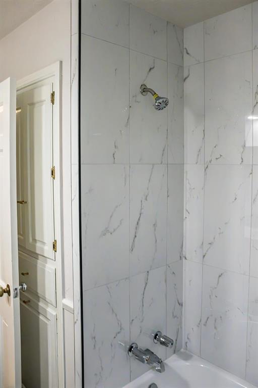 bathroom with tiled shower / bath combo