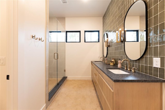 bathroom featuring vanity, a shower with door, and tasteful backsplash