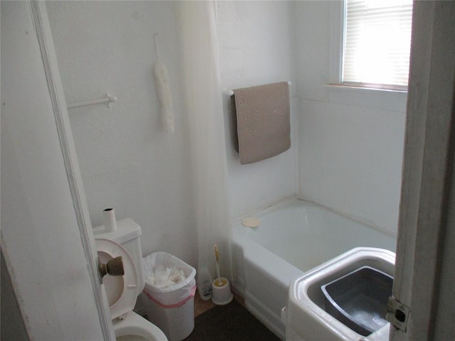 bathroom featuring toilet and a tub