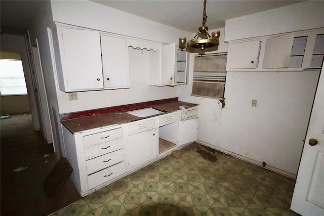 kitchen with white cabinets, pendant lighting, and an inviting chandelier