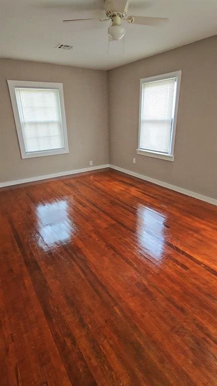 spare room with hardwood / wood-style flooring, plenty of natural light, and ceiling fan