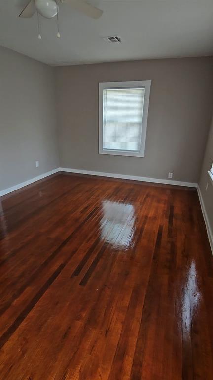 spare room featuring ceiling fan and dark wood-type flooring