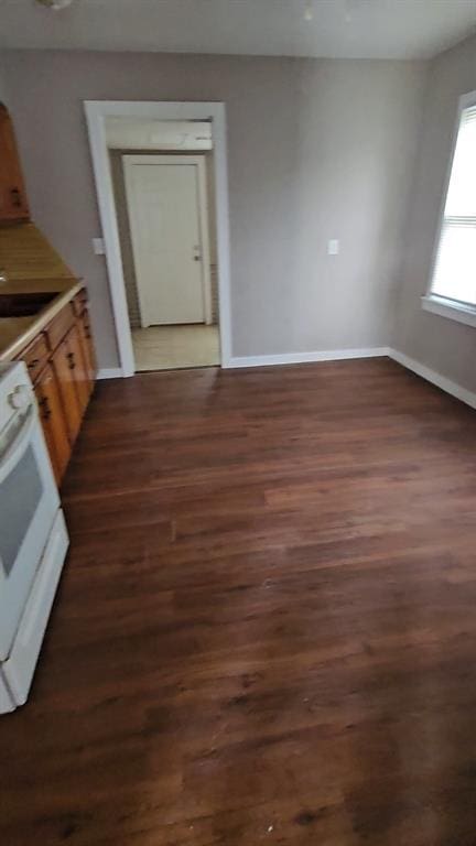 kitchen featuring white range oven, dark hardwood / wood-style flooring, and sink