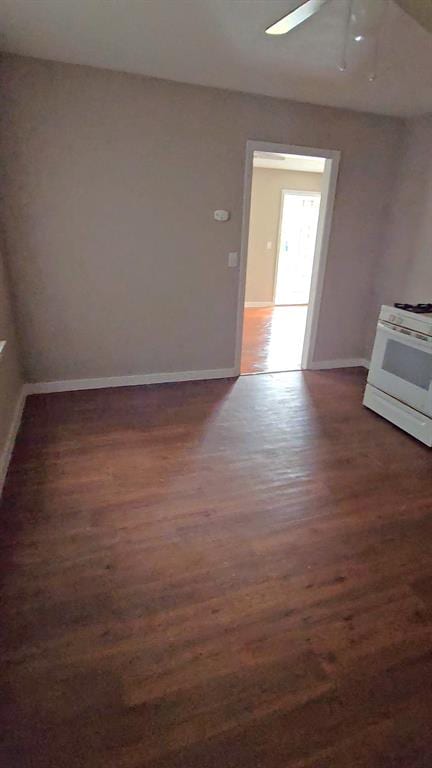 unfurnished living room featuring ceiling fan and dark hardwood / wood-style floors