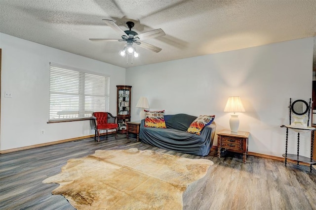 living area featuring hardwood / wood-style floors, a textured ceiling, and ceiling fan