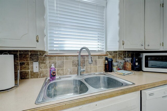 kitchen with white cabinets, dishwasher, backsplash, and sink