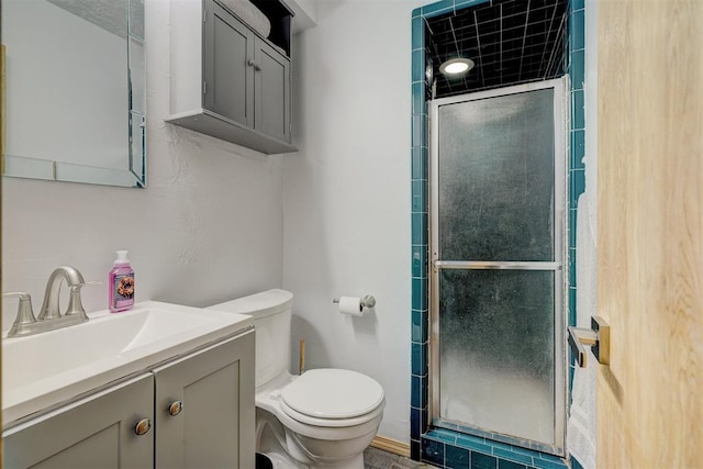 bathroom featuring vanity, an enclosed shower, and toilet