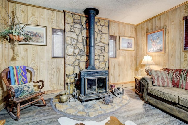 living room featuring a wood stove, wooden walls, and wood-type flooring