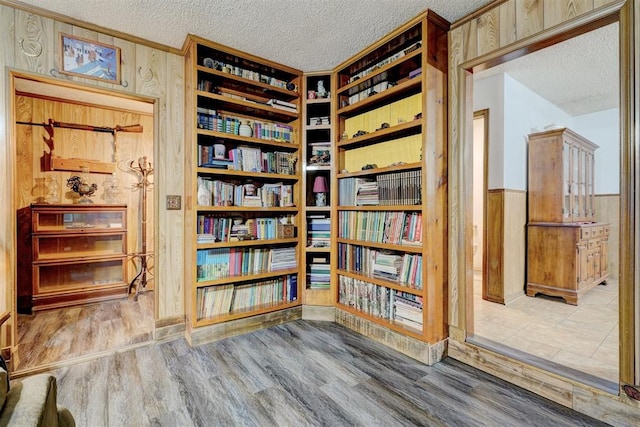 unfurnished room with a textured ceiling, hardwood / wood-style flooring, and wood walls