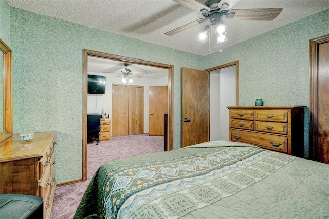 bedroom with ceiling fan, light colored carpet, and a textured ceiling