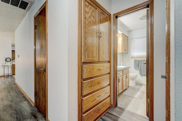 hall with a textured ceiling and dark hardwood / wood-style floors