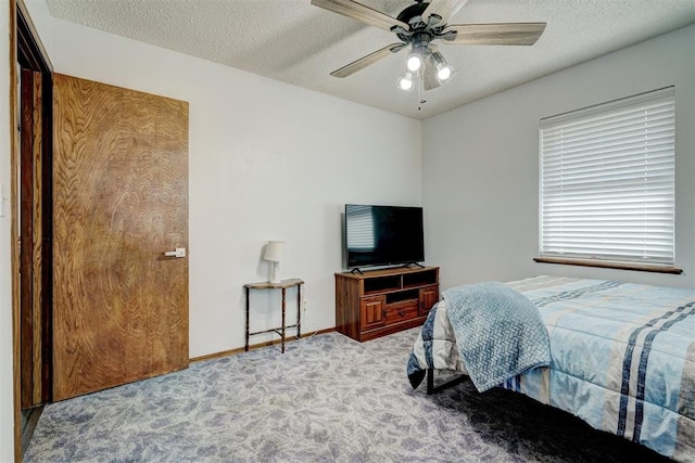 bedroom featuring a textured ceiling, light colored carpet, and ceiling fan