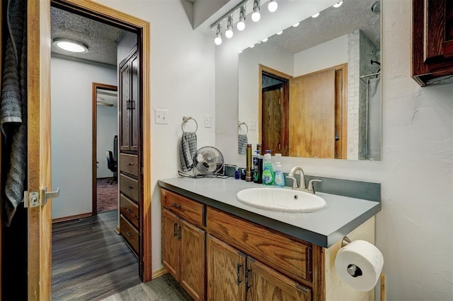 bathroom featuring hardwood / wood-style floors, vanity, and a textured ceiling