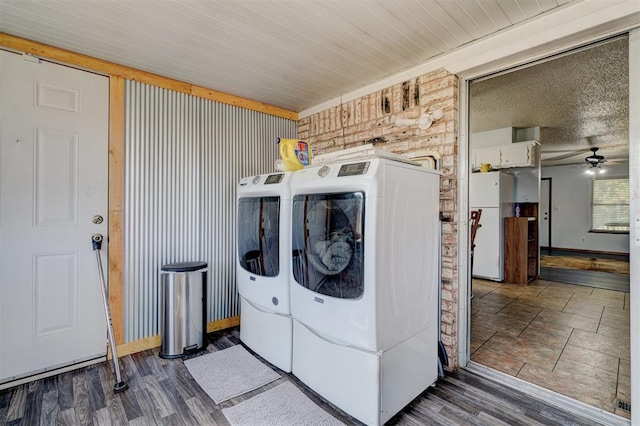 laundry area with wood walls, dark hardwood / wood-style floors, ceiling fan, and washing machine and dryer