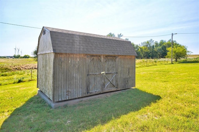 view of outdoor structure featuring a yard and a rural view