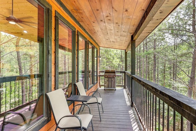 unfurnished sunroom with wooden ceiling and ceiling fan