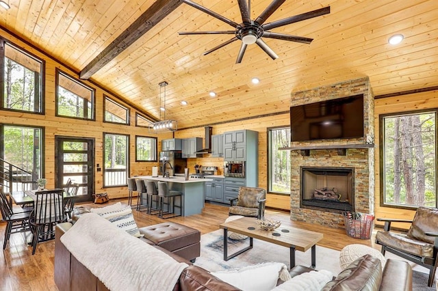 living room featuring wood ceiling, wooden walls, high vaulted ceiling, and light wood-type flooring