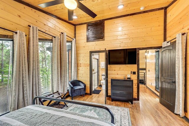 bedroom with ceiling fan, wooden walls, light hardwood / wood-style flooring, and wooden ceiling