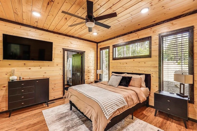 bedroom featuring ceiling fan, wooden ceiling, wooden walls, and light wood-type flooring