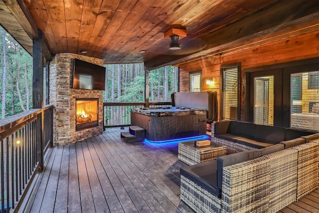 wooden deck with an outdoor living space with a fireplace and ceiling fan