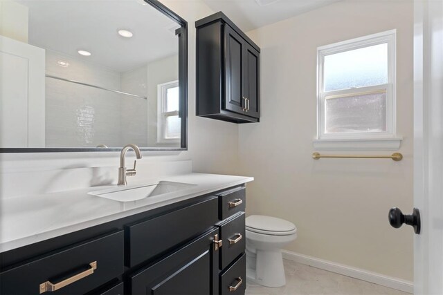 bathroom with tile patterned floors, vanity, toilet, and walk in shower