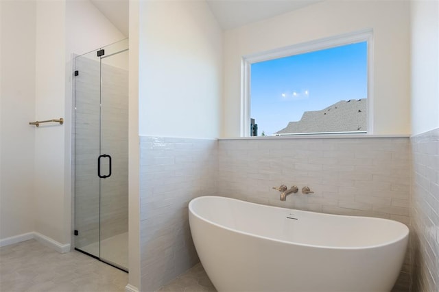 bathroom with tile patterned floors, separate shower and tub, and tile walls