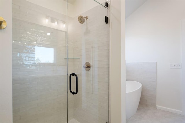 bathroom featuring separate shower and tub, tile patterned floors, and tile walls