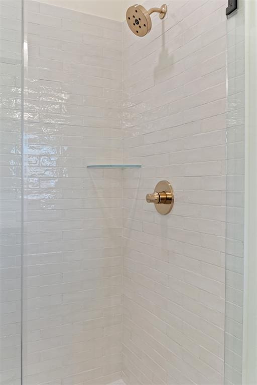 interior details featuring a tile shower