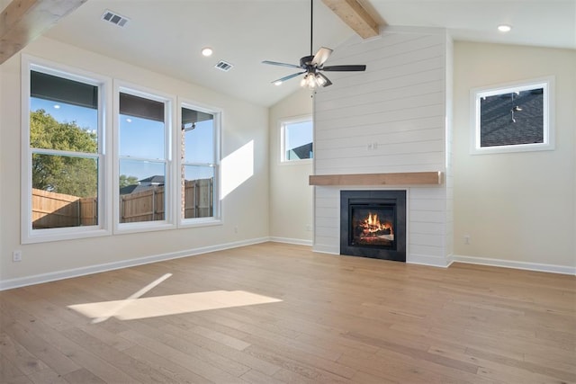 unfurnished living room with beam ceiling, a large fireplace, light hardwood / wood-style floors, and ceiling fan