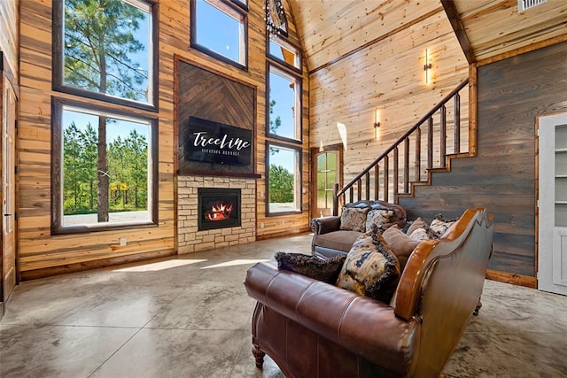 living room featuring wood walls, high vaulted ceiling, a fireplace, concrete floors, and beam ceiling