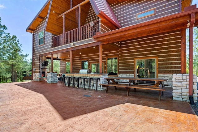 view of patio / terrace with grilling area, ceiling fan, a balcony, and an outdoor bar