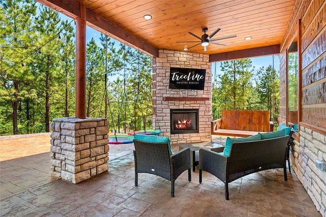 view of patio featuring ceiling fan and an outdoor stone fireplace