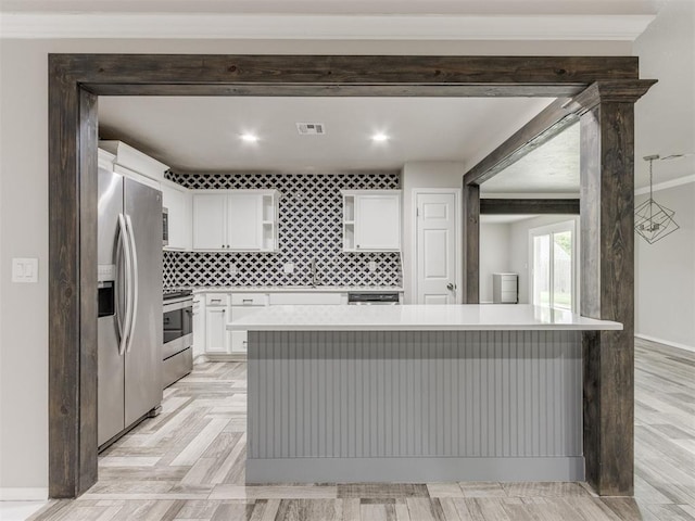 kitchen featuring backsplash, a kitchen island, white cabinetry, and stainless steel appliances