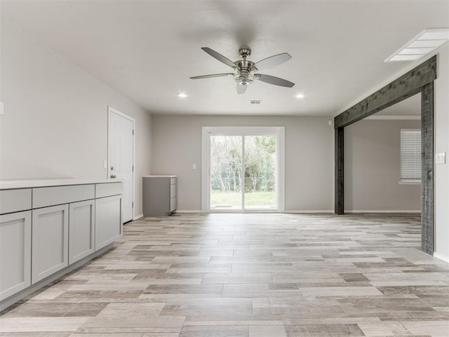 unfurnished living room with ceiling fan and light hardwood / wood-style floors