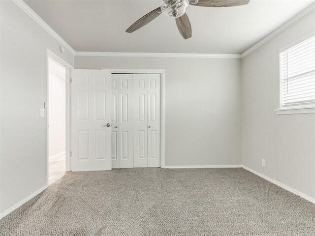 unfurnished bedroom featuring carpet flooring, a closet, ceiling fan, and ornamental molding