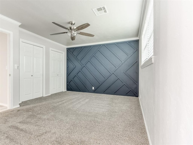 carpeted spare room with ceiling fan and ornamental molding