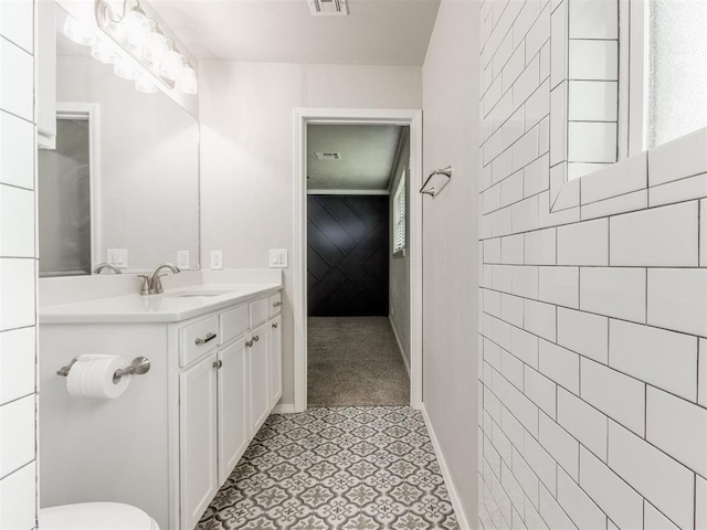 bathroom with vanity and tile walls