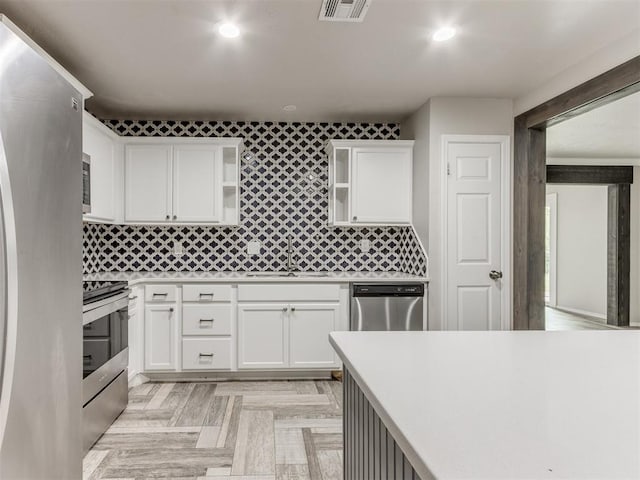 kitchen with tasteful backsplash, white cabinetry, and stainless steel appliances