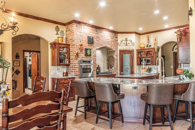 12600 SW 58th St, Mustang, OK 73064 - kitchen featuring a kitchen breakfast bar, light stone countertops, kitchen peninsula, and stainless steel appliances