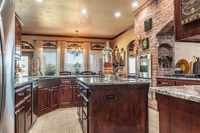 12600 SW 58th St, Mustang, OK 73064 - kitchen with dark stone countertops, plenty of natural light, decorative light fixtures, and sink