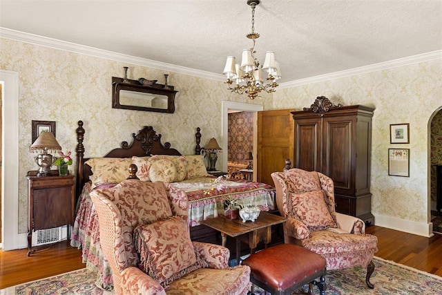 bedroom with a textured ceiling, crown molding, dark wood-type flooring, and a chandelier