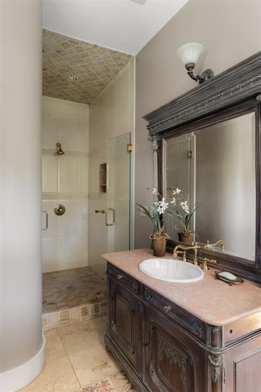 bathroom with tile patterned floors, vanity, and walk in shower